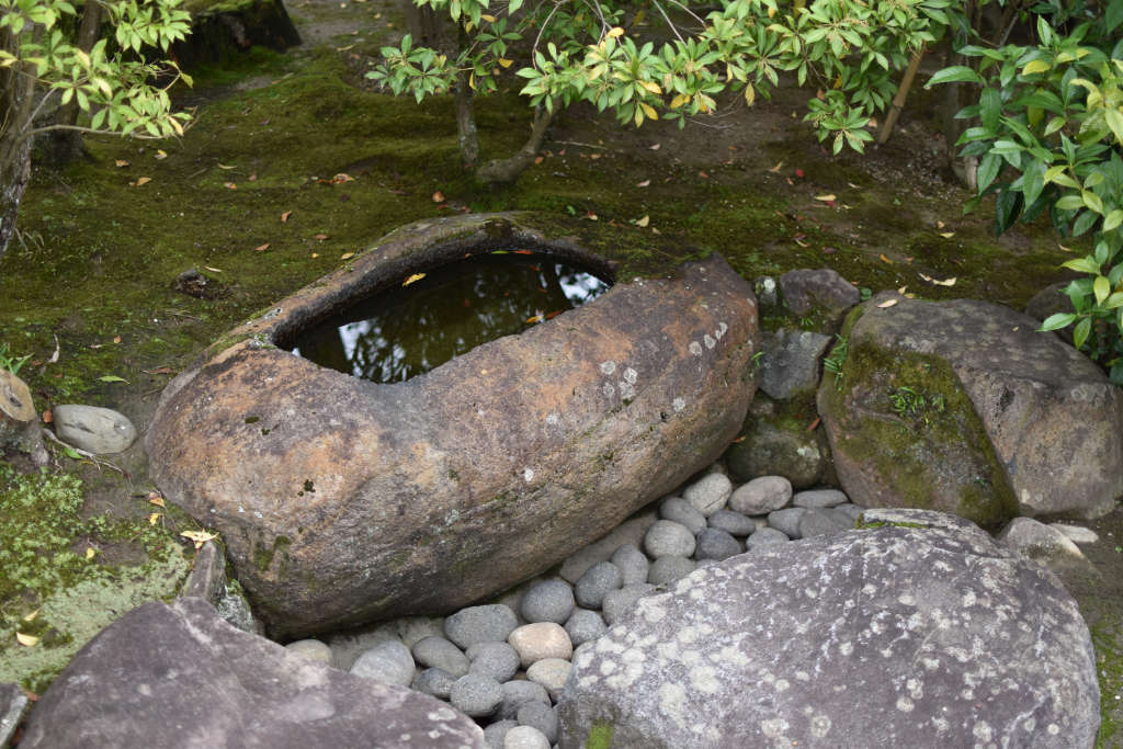 Bassin en pierre servant à la purification, dans un jardin japonais